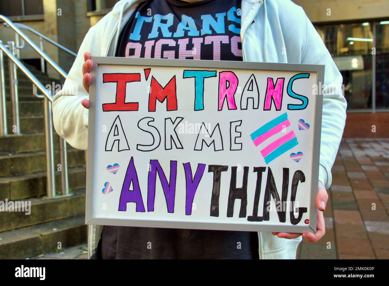 Glasgow, Schottland, Vereinigtes Königreich 28. Januar 2023. Der Trans-Aktivist Alexander Cart protestiert gegen die Donald Dewar-Statue und bietet den Bürgern einen offenen und ehrlichen dialog mit allen Fragen, die sie beantworten wollen. Ein umweltfreundlicher Protest mit einem Protest auf Kreidebasis, der für Klarheit auf den Statuen Sockel verbessert wurde, der auf Kreidebasis basiert und im Regen verschwinden wird, der die Stadt Credit Gerard Ferry/Alamy Live News heimsucht Stockfoto