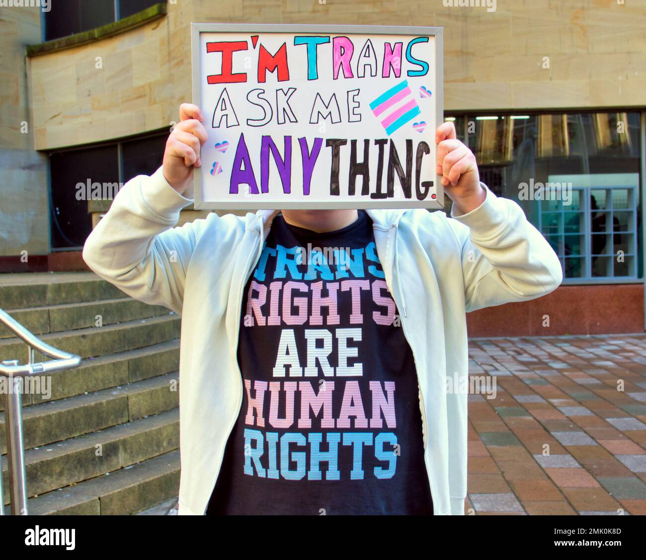 Glasgow, Schottland, Vereinigtes Königreich 28. Januar 2023. Der Trans-Aktivist Alexander Cart protestiert gegen die Donald Dewar-Statue und bietet den Bürgern einen offenen und ehrlichen dialog mit allen Fragen, die sie beantworten wollen. Ein umweltfreundlicher Protest mit einem Protest auf Kreidebasis, der für Klarheit auf den Statuen Sockel verbessert wurde, der auf Kreidebasis basiert und im Regen verschwinden wird, der die Stadt Credit Gerard Ferry/Alamy Live News heimsucht Stockfoto