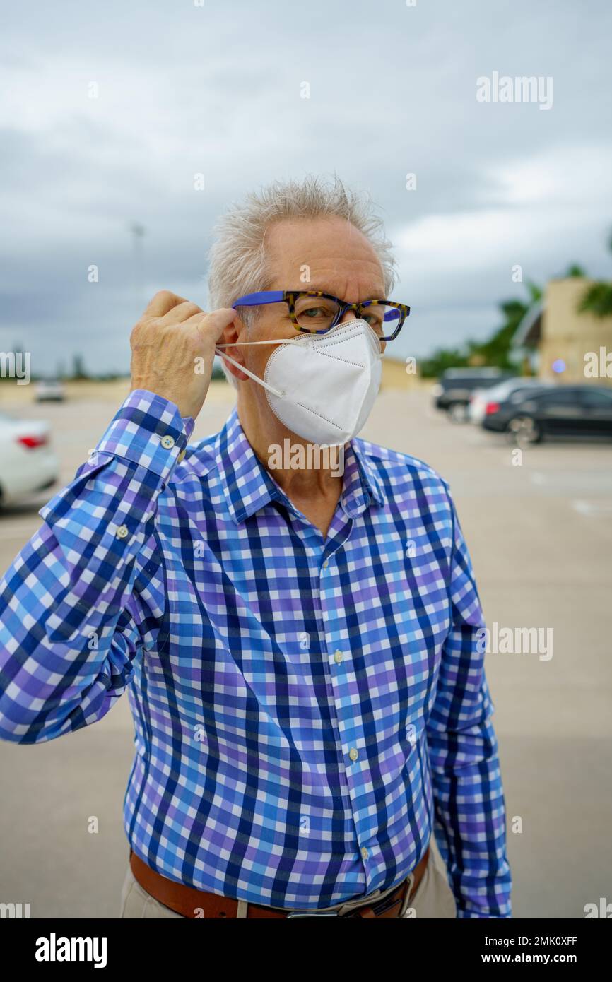 Senior-Mann, der gerne seine Gesichtsmaske entfernt Stockfoto