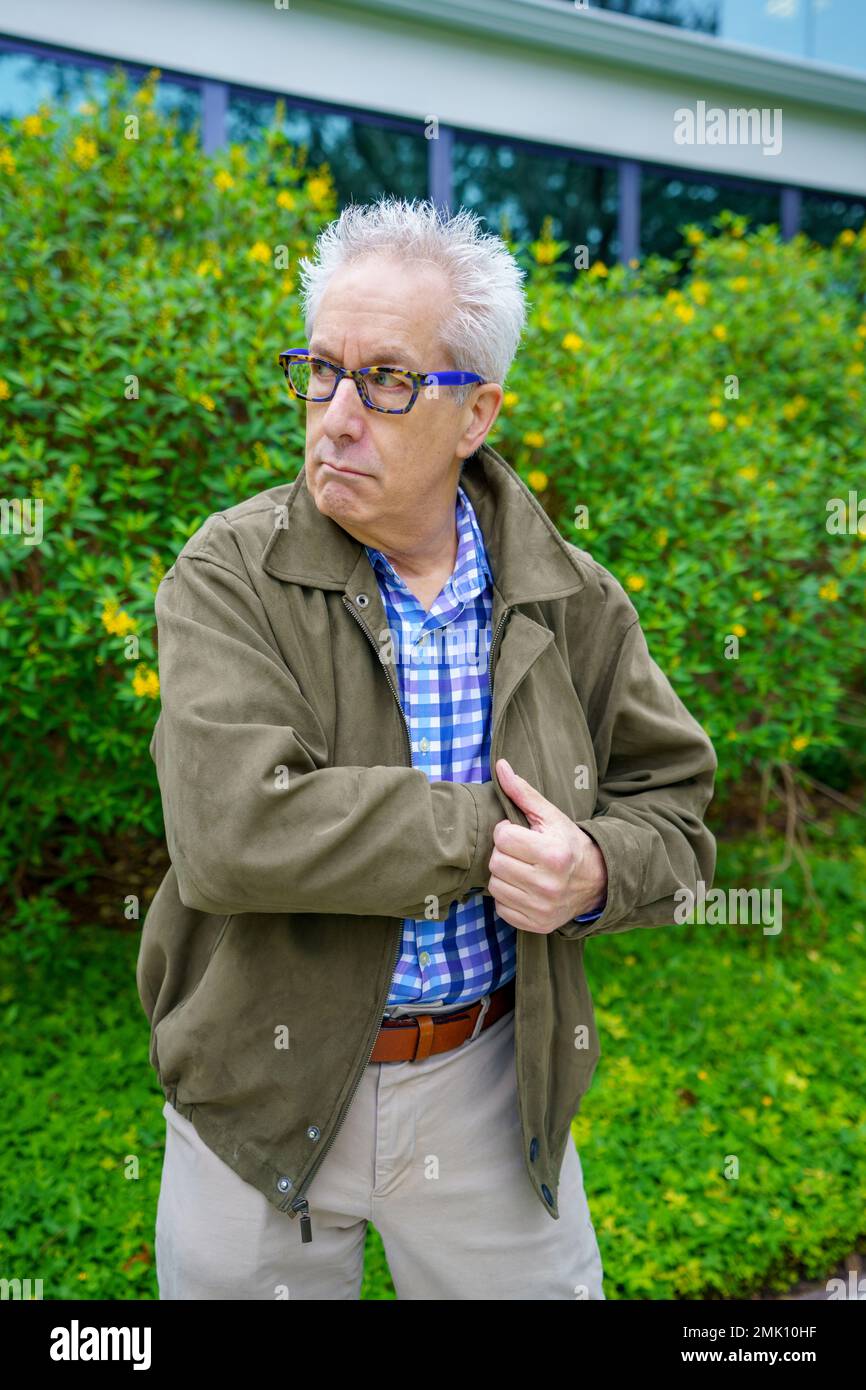 Undercover-Agent greift in seine Jacke nach einer Waffe Stockfoto