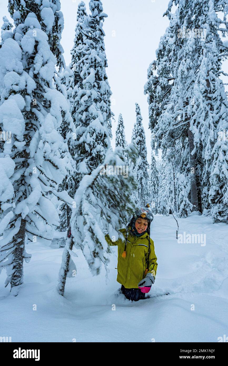 Fröhlicher Junge, der Spaß beim Spielen im verschneiten Wald hat, ISO Syote, Nordostrobothnia, Lappland, Finnland Stockfoto