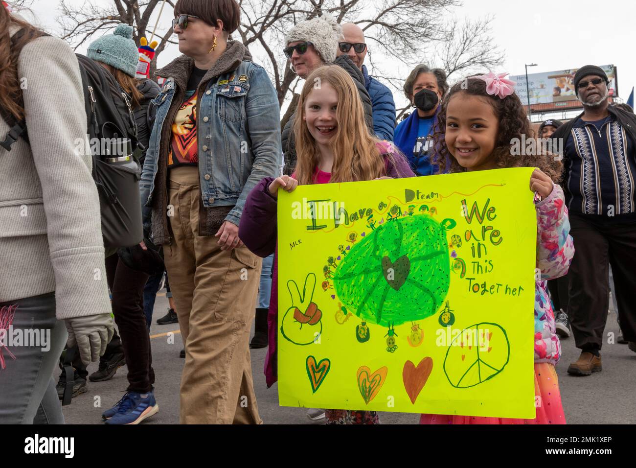 Denver, Colorado - die jährliche Martin Luther King Day Marade (märz + Parade). Zwei Mädchen, eine schwarz und eine weiß, tragen ein Schild, wenn sie zusammen marschieren. Stockfoto