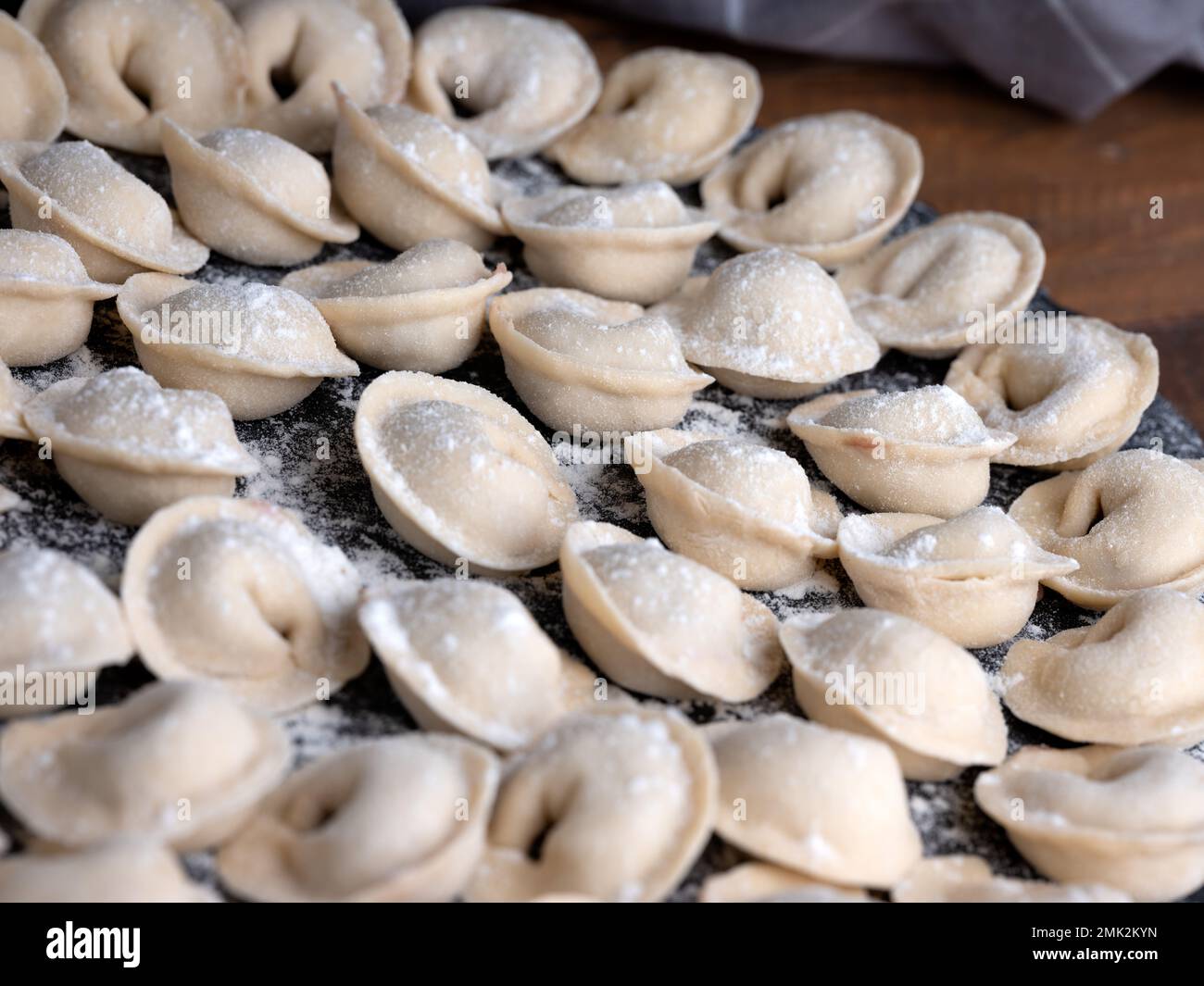 Studio-Aufnahme von handgefertigten russischen Knödeln (Pelmeni) — traditionelle Lebensmittelkunst in einer sauberen, minimalen Umgebung. Stockfoto