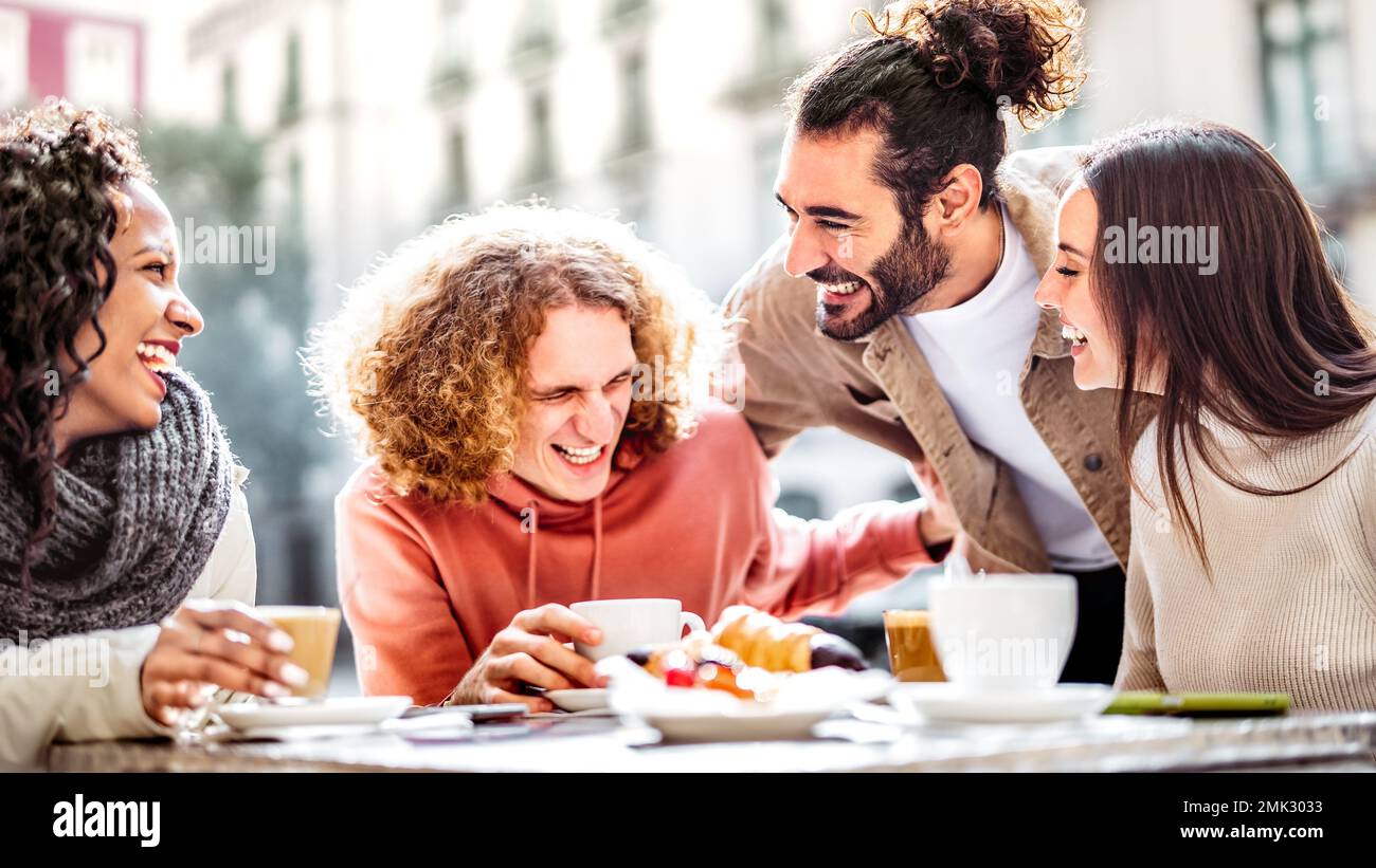 Glückliche Paare, die Cappuccino auf der Terrasse der Café-Bar trinken - junge Leute, die sich unterhalten und Spaß zusammen in der Straßencafeteria haben - Lifestyle-Konzept Stockfoto