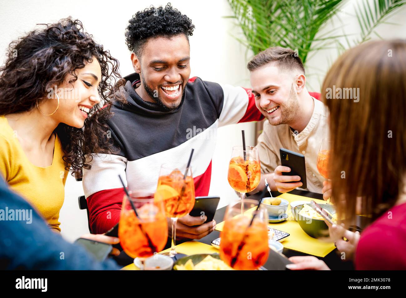 Gäste teilen sich den Spritz im Cocktailbar-Restaurant - das Lifestyle-Konzept mit jungen Freunden, die Spaß zusammen haben, während der Happy Hour Drinks zu trinken Stockfoto