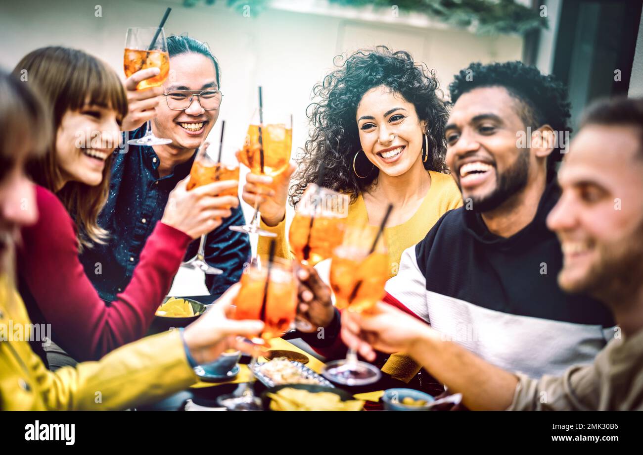 Trendige Freunde stoßen einen Spritz Cocktail im Bar-Restaurant an - Lifestyle-Konzept mit jungen Leuten, die Spaß zusammen haben, während der Happy Hour Drinks zu trinken Stockfoto