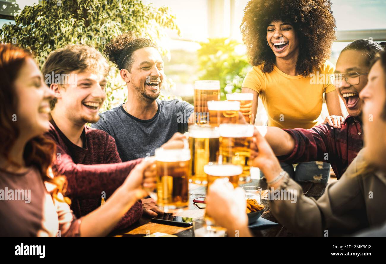Multirassische Freunde trinken und toasten Bier im Brauereirestaurant - Beverage Life Style Konzept, während Mann und Mädchen Spaß miteinander haben Stockfoto