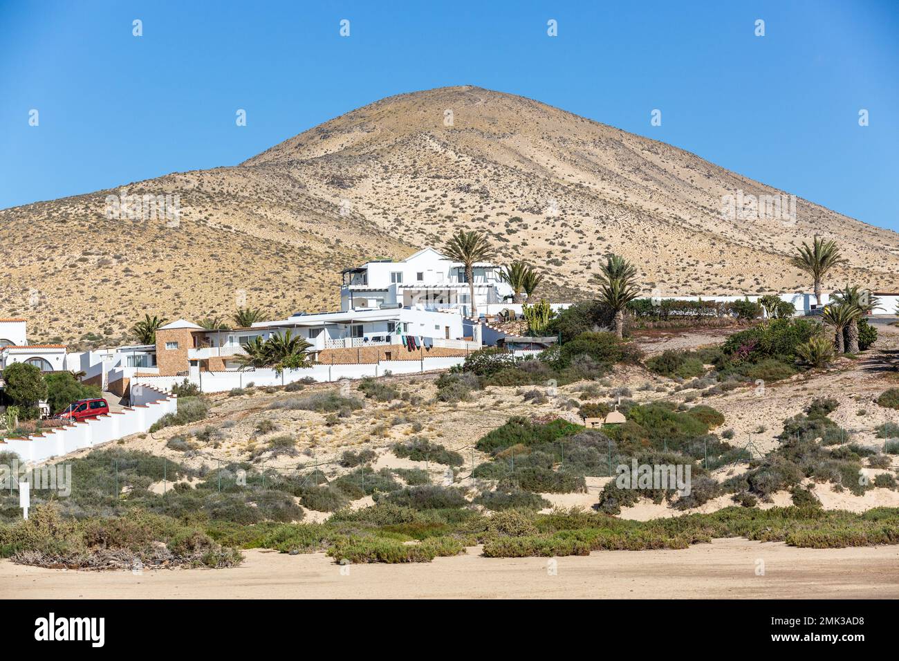 Moderne Residenz, alle in Weiß, auf der Seite eines Hügels am Rande des Sotavento Strandes erbaut. Stockfoto