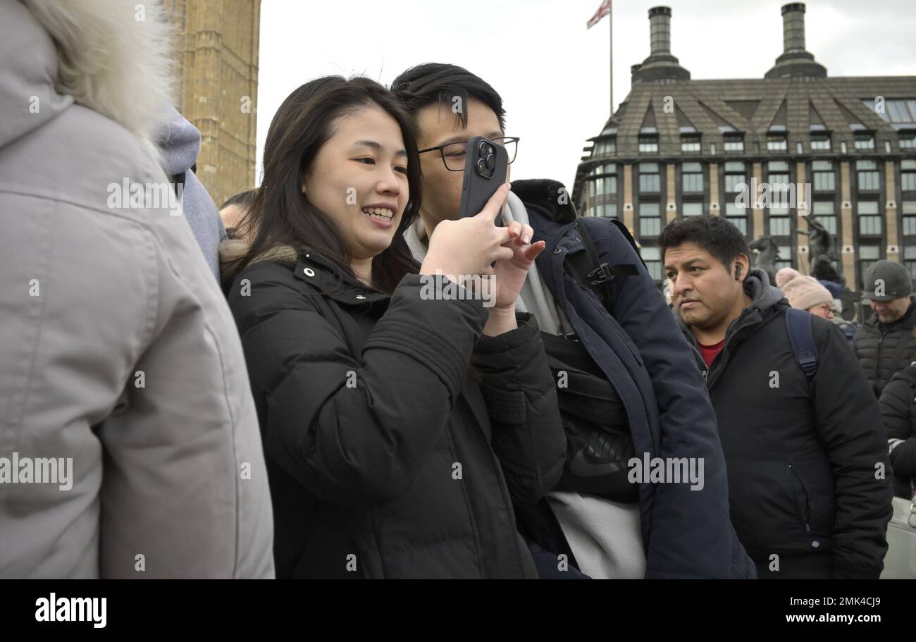 London, England, Großbritannien. Ein junges asiatisches Paar, das für ein Selfie auf der Westminster Bridge posiert. Stockfoto