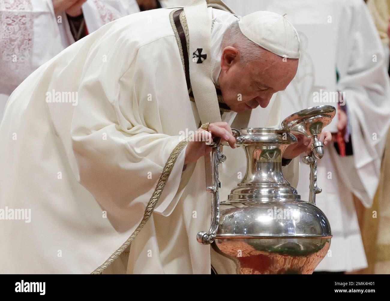 Pope Francis blows inside an amphora containing holy oil during a Chrism Mass inside St. Peter's Basilica, at the Vatican, Thursday, April 18, 2019. During the Mass the Pontiff blesses a token amount of oil that will be used to administer the sacraments for the year. (AP Photo/Alessandra Tarantino) Stockfoto