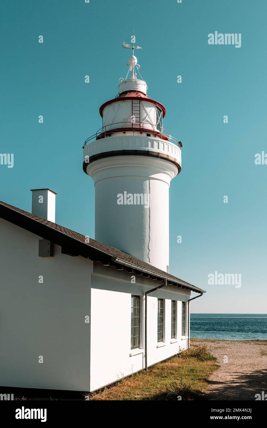 Dänemark, Jütland, Djursland: Der weiße runde Leuchtturm Sletterhage auf der Halbinsel Helganaes in der Sonne vor einem blauen, wolkenlosen Himmel. Stockfoto
