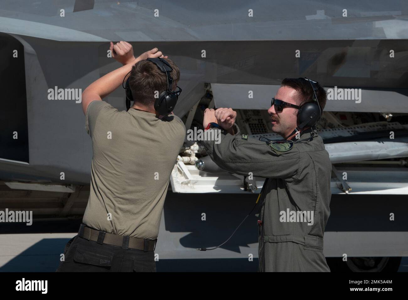 Die US Air Force Airmen 1. Class Thatcher Deese, links, Crew-Chef, und Capt. „Swiss“ Ritschard, F-22 Raptor-Pilot, beide dem Expeditionary Fighter Squadron von 90. zugewiesen, führen einen F-22 Raptor an, um während Ritschards ‘Crew Chief für ein eintägiges Eintauchen auf dem Luftwaffenstützpunkt Łask, Polen, am 5. September 2022, zu parken. ‘Crew Chief for a Day“ ermöglicht es Piloten, sich durch tägliche Aufgaben wie Inspektionen, Bergung und Betankung mit dem Wartungspersonal zu integrieren. Das Eintauchen trägt dazu bei, die Moral und den Teamaufbau innerhalb der Staffel zu stärken. Die Präsenz der 90. in der Region stärkt die Einheit der USA und der NATO jeden Tag, wenn die Streitkräfte zusammenkommen Stockfoto