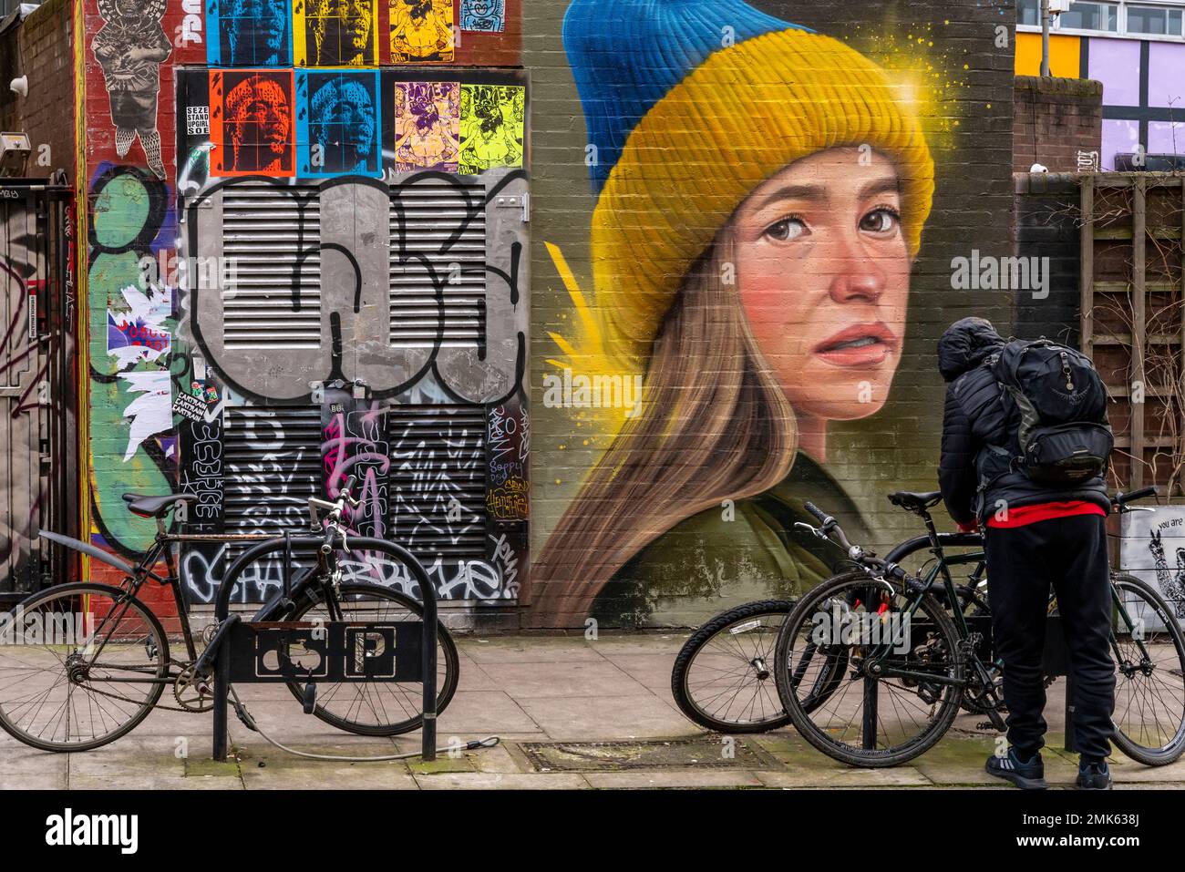Ein Mann sperrt sein Fahrrad in Shoreditch, East London, London, UK. Stockfoto