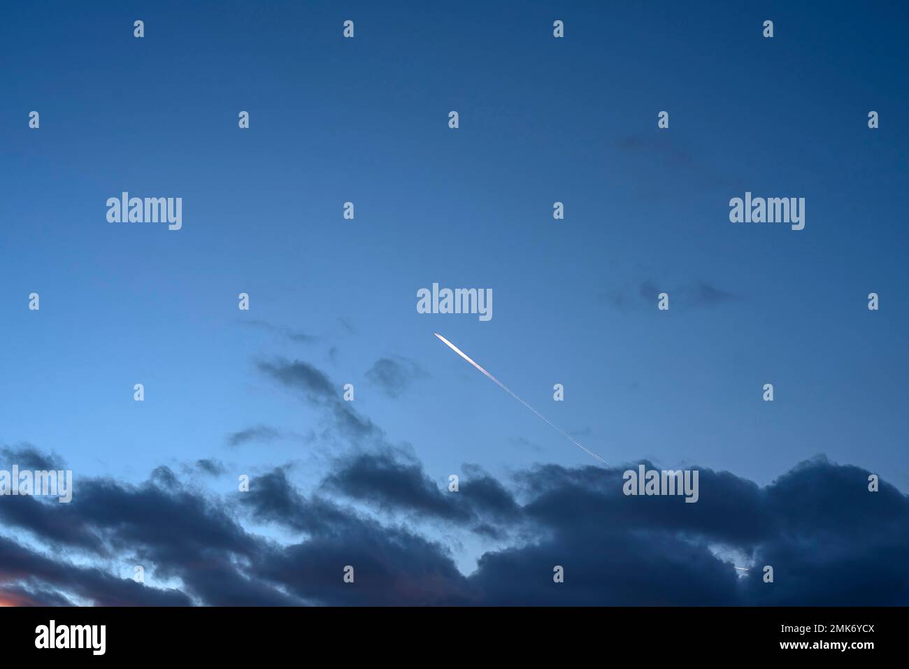 Dunkle Wolken am Abendhimmel, Flugzeug mit Kondensationswegen, Bayern, Deutschland Stockfoto