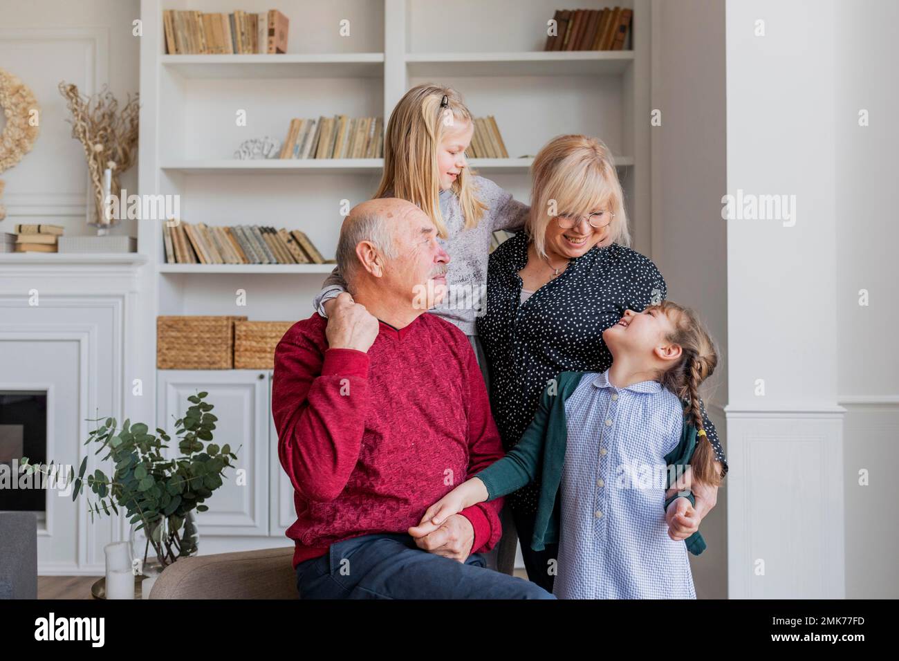 Mittelgroße, glückliche Familie drinnen. Hochauflösendes Foto Stockfoto