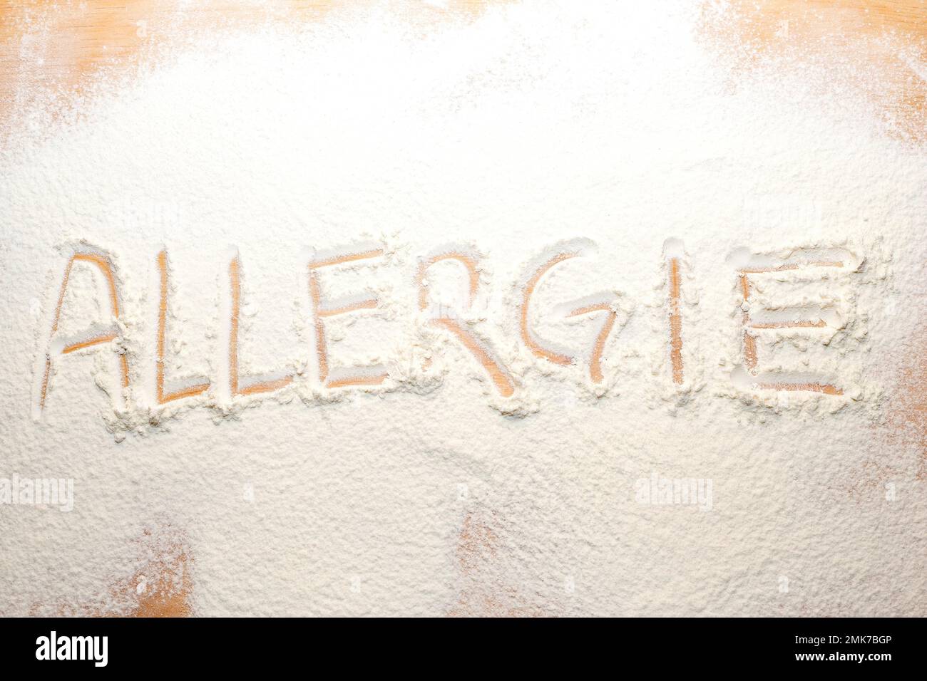 Das Wort Allergie wurde in Mehl auf einem Nudelbrett geschrieben Stockfoto