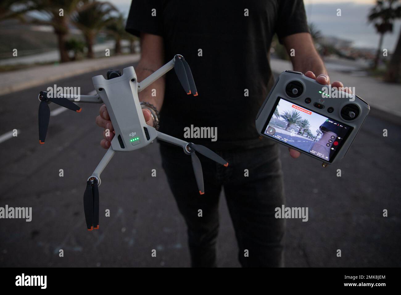 Teneriffa, Spanien, 27. Januar 2023: Ein Drohnenpilot mit der neuen DJI mini 3 Pro Drohne und der Fernbedienung mit Bildschirm Stockfoto