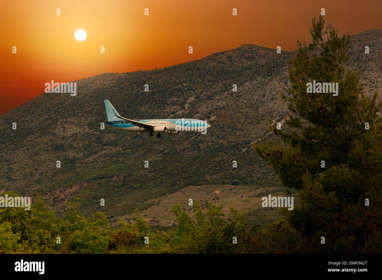 Flugzeug landet im Flughafen Dubrovnik (Cavtat) bei Sonnenuntergang. Stockfoto