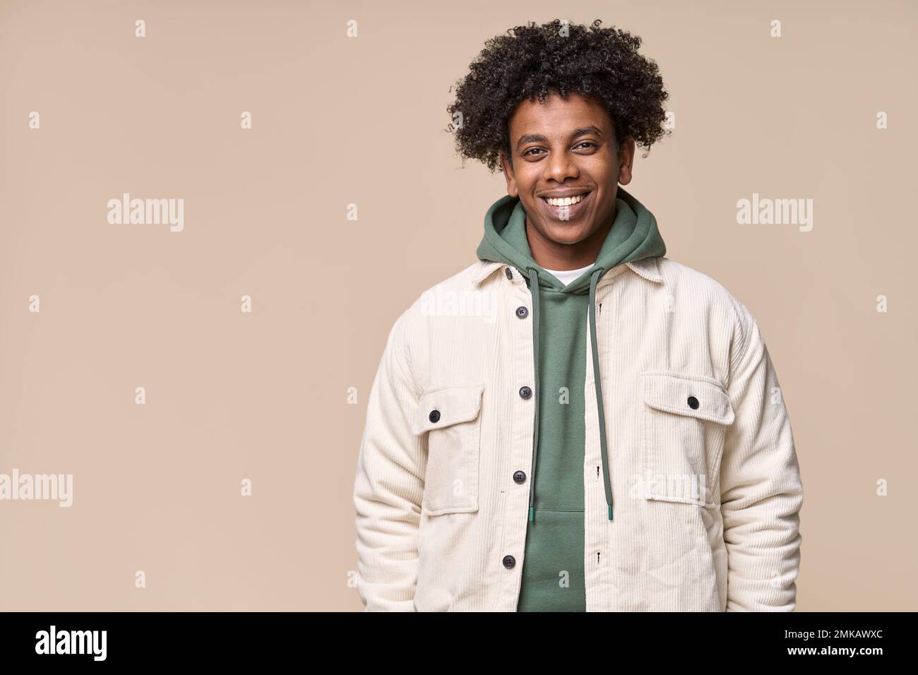Lächelnder, cooler afroamerikanischer Teenager, isoliert auf beigefarbenem Hintergrund. Stockfoto