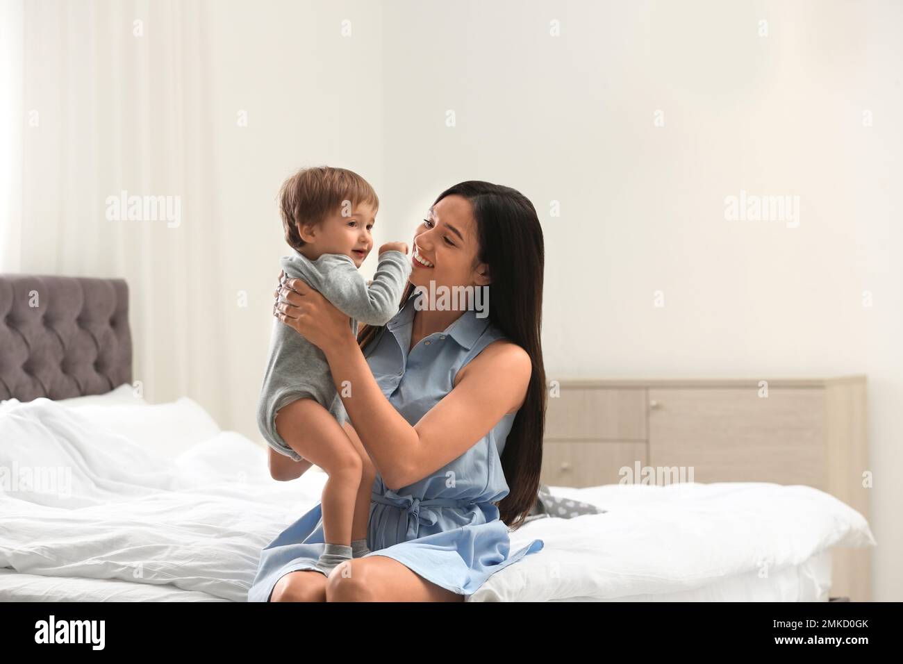 Junge Nanny mit süßem Baby im Schlafzimmer Stockfoto