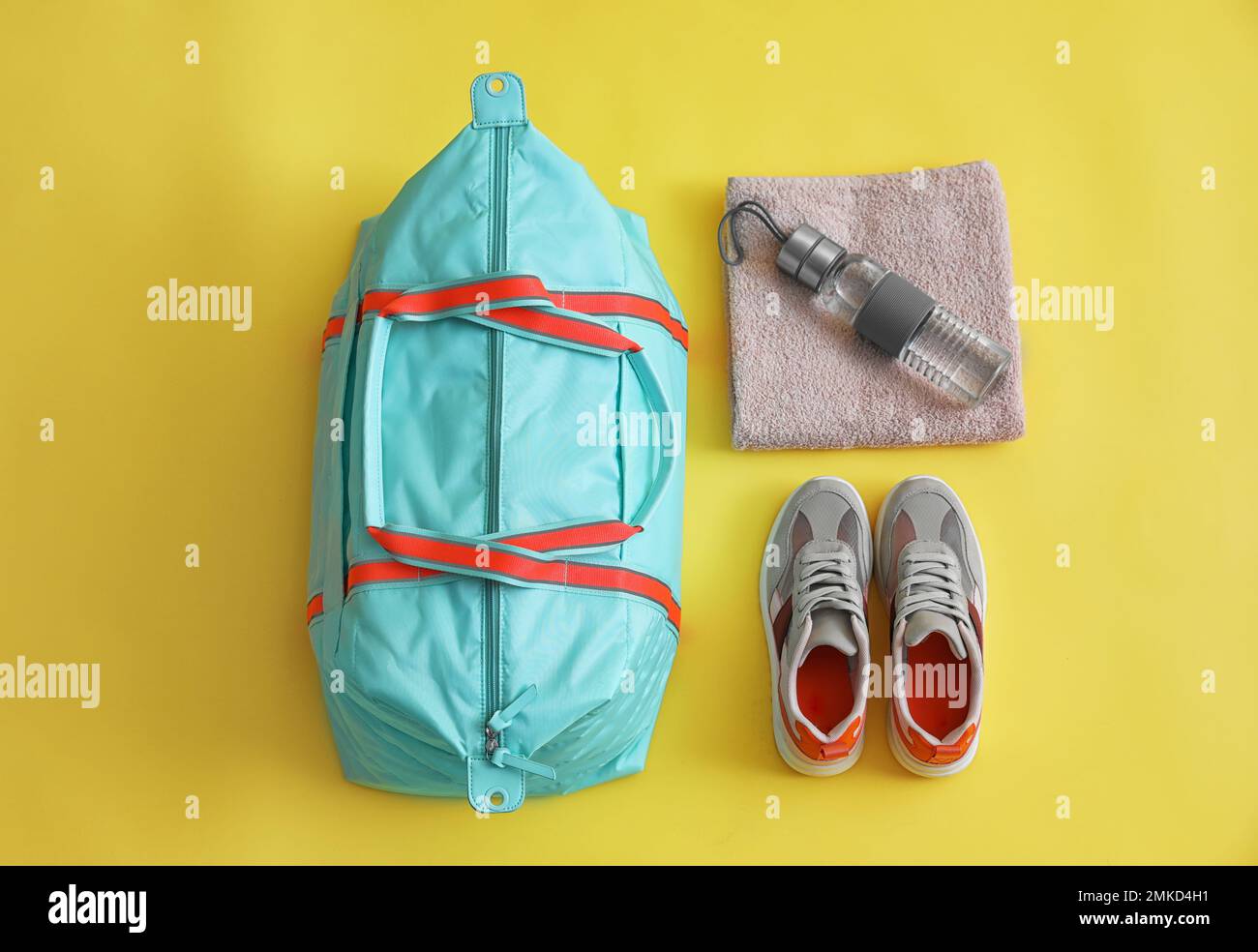 Sporttasche und Sportausrüstung auf gelbem Hintergrund, flach liegend Stockfoto