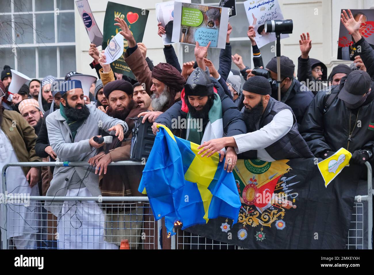 London, Großbritannien. 28. Januar 2023 Demonstranten versuchen, die schwedische Flagge anzuzünden. Muslimische Demonstranten haben sich versammelt, um die Schändung des Koran durch den rechtsextremen Politiker Rasmus Paludan anzuprangern - durch Verbrennung und Edwin Wagensveld in den Niederlanden, der den heiligen Text zerrissen hat. Das ursprüngliche Feuer des dänisch-schwedischen Paludan wurde vor der türkischen Botschaft in Stockholm durchgeführt, und die schwedische Regierung versuchte, sich von der Demonstration zu distanzieren. Kredit: Elfte Stunde Fotografie/Alamy Live News Stockfoto