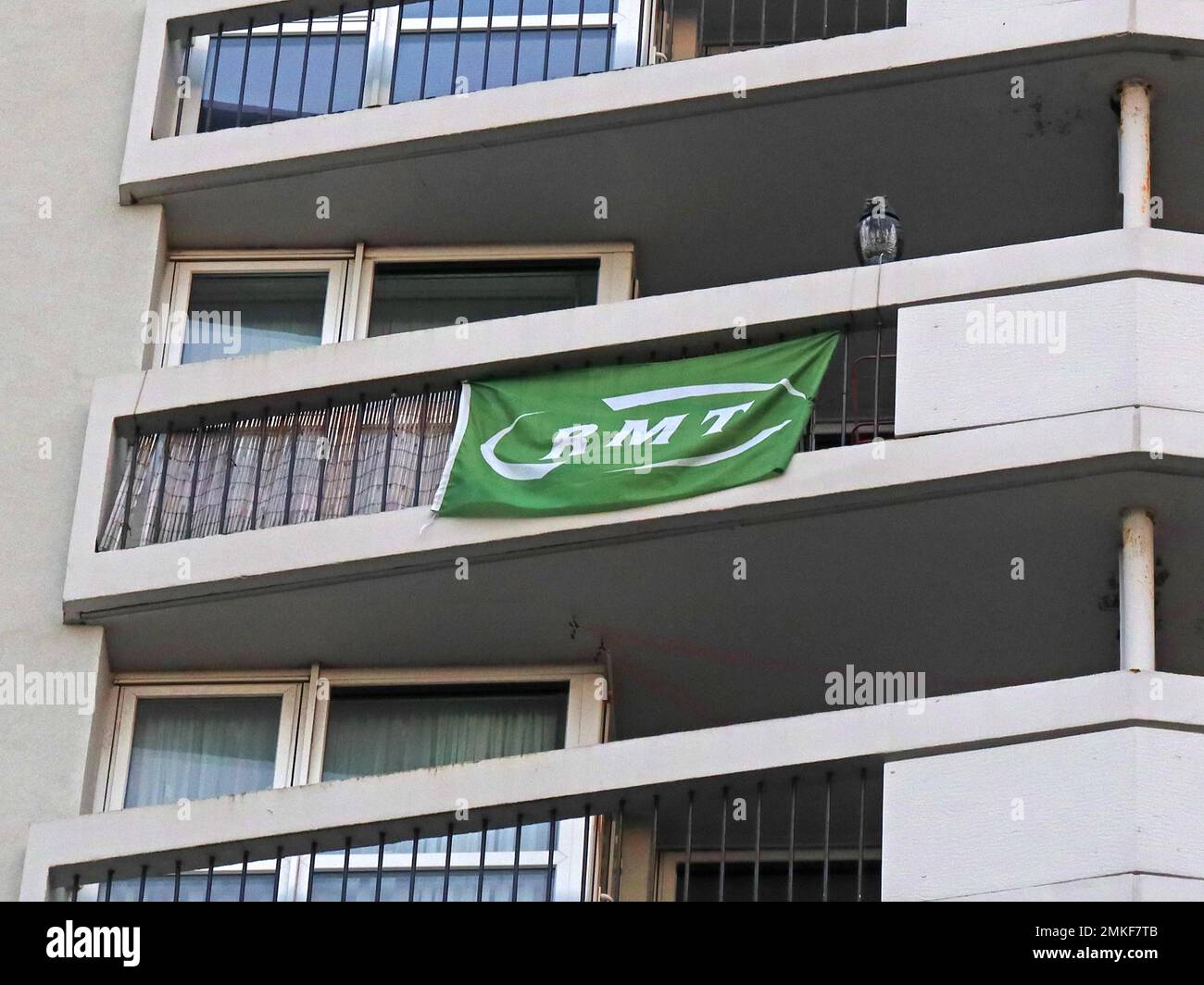 Unterstützung für RMT-Gewerkschaftsstreiks, grüne Flagge, die von einem Wohnungsbalkon in einem Block fliegt, Scholes, Central Wigan, Lancashire, England, UK, WN1 Stockfoto