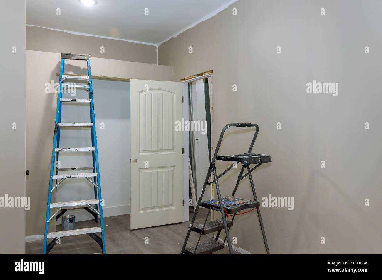 Der Raum ist mit einer bemalten Wand mit Malerausrüstung und einer Trittleiter ausgestattet Stockfoto