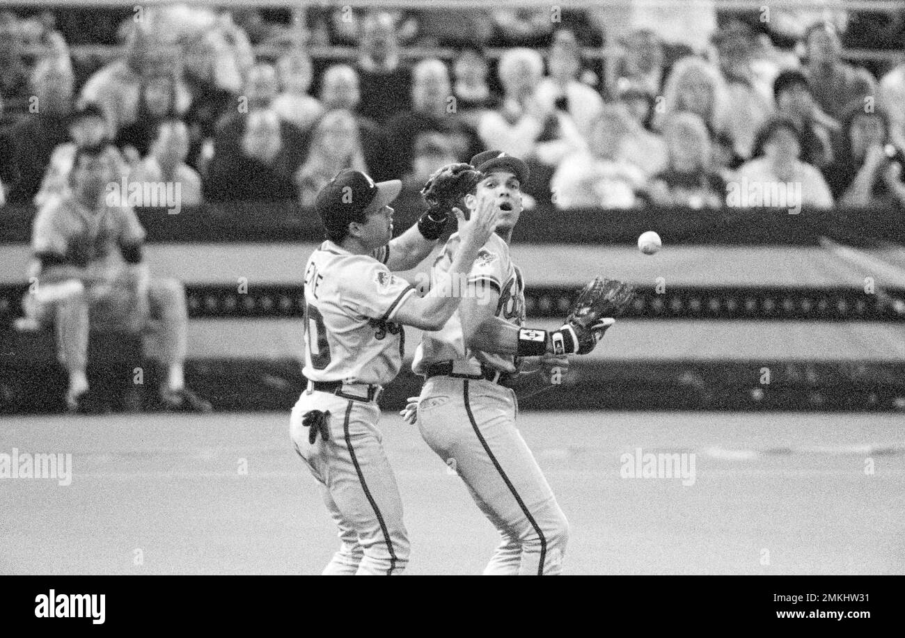 The Atlanta Braves' Mark Lemke, left, and David Justice lose a pop fly from the Minnesota Twins' Dan Gladden during the first inning of Game 2 of the World Series in Minneapolis, Oct. 21, 1991. An error was charged to Justice and Gladden made it to second base. (AP Photo/Doug Mills) Stockfoto