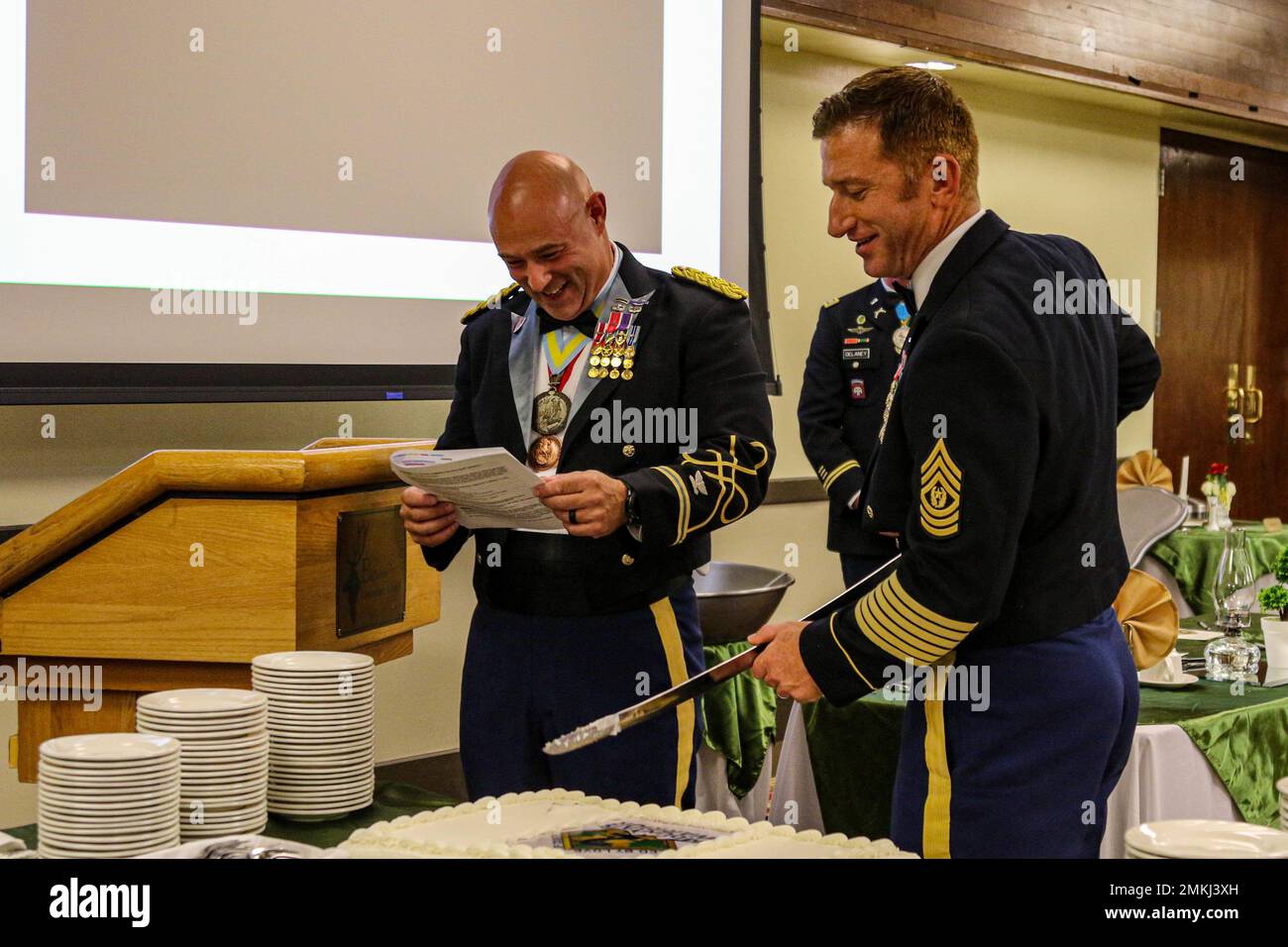 Oberst Andy Kiser, links, Kommandant der 2. Stryker Brigade Combat Team, 4. Infanterie Division, liest ein Skript, während Command Sgt. Maj. Michael Eiermann, rechts, Kommandofeldwebel Major von 2. SBCT, 4. Inf. Div., schneidet einen Kuchen während eines Essens in Ft. Carson, Colorado, September 9. Die Brigade veranstaltete das Abendessen, um seine Vergangenheit zu feiern, ein zusammengehörigeres Team aufzubauen und eine soziale Atmosphäre für Kameradschaft und Spaß zu schaffen. Foto der US-Armee von Maj. Jason Elmore. Stockfoto