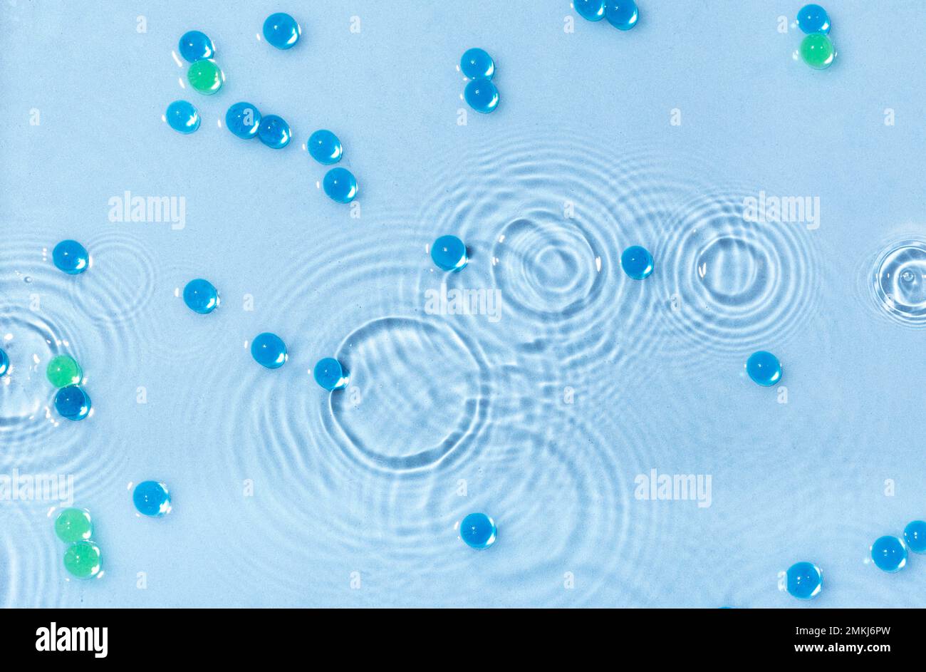 Abstraktes Wasser, kosmetischer Hintergrund mit Wellen und Wellen und kugelförmigen Granulaten. Konzept therapeutischer feuchtigkeitsspendender Kosmetika Stockfoto