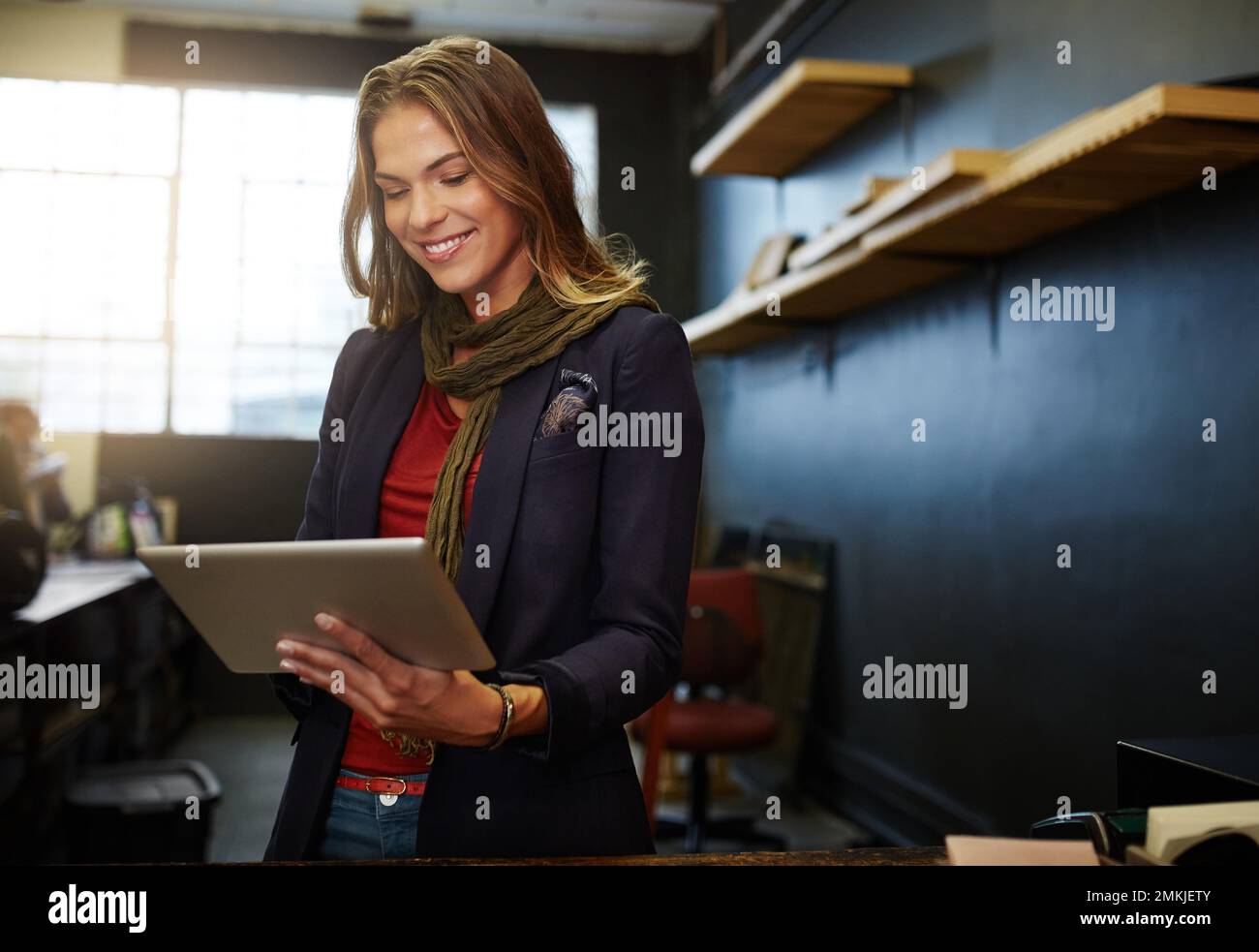 Ihr Geschäft online zu vermarkten. Eine junge Geschäftsinhaberin, die in ihrem Geschäft ein digitales Tablet verwendet. Stockfoto