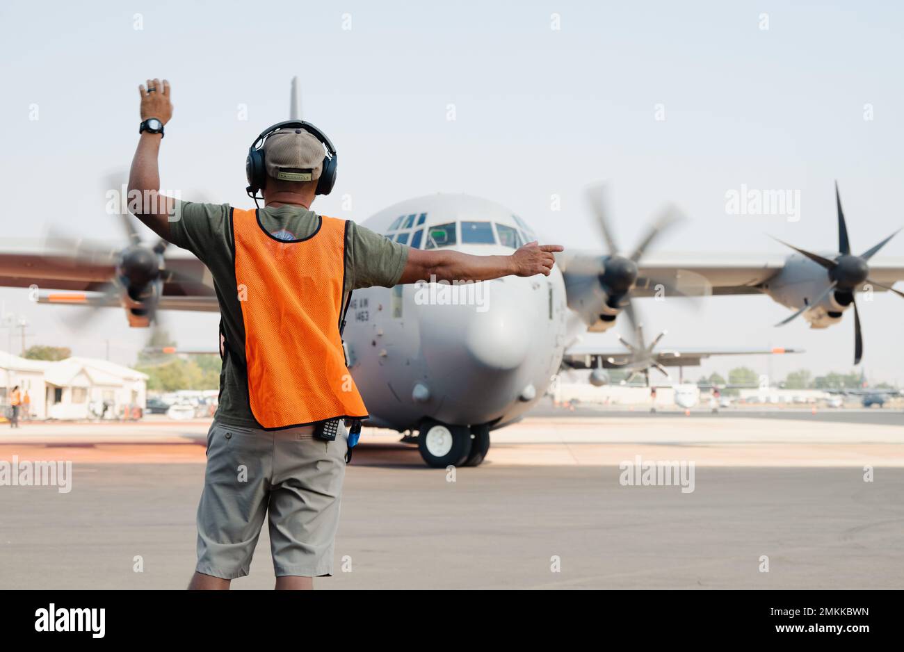 Ein US Forest Service Modular Airborne Firefighting Systems (MAFFS) Airtanker Base Specialist (ABS) führt ein C-130J Super Hercules Flugzeug vom 146. Airlift Wing der California Air National Guard auf der Boise Tanker Base, Idaho, 10. September 2022 durch. Das United States Department of Agriculture Forest Service hat zwei mit MAFFS ausgestattete Flugzeuge des Verteidigungsministeriums C-130 aktiviert, um die Brandausbreitung in mehreren westlichen Staaten zu unterstützen. (Foto der Air National Guard vom Senior Airman Thomas Cox) Stockfoto