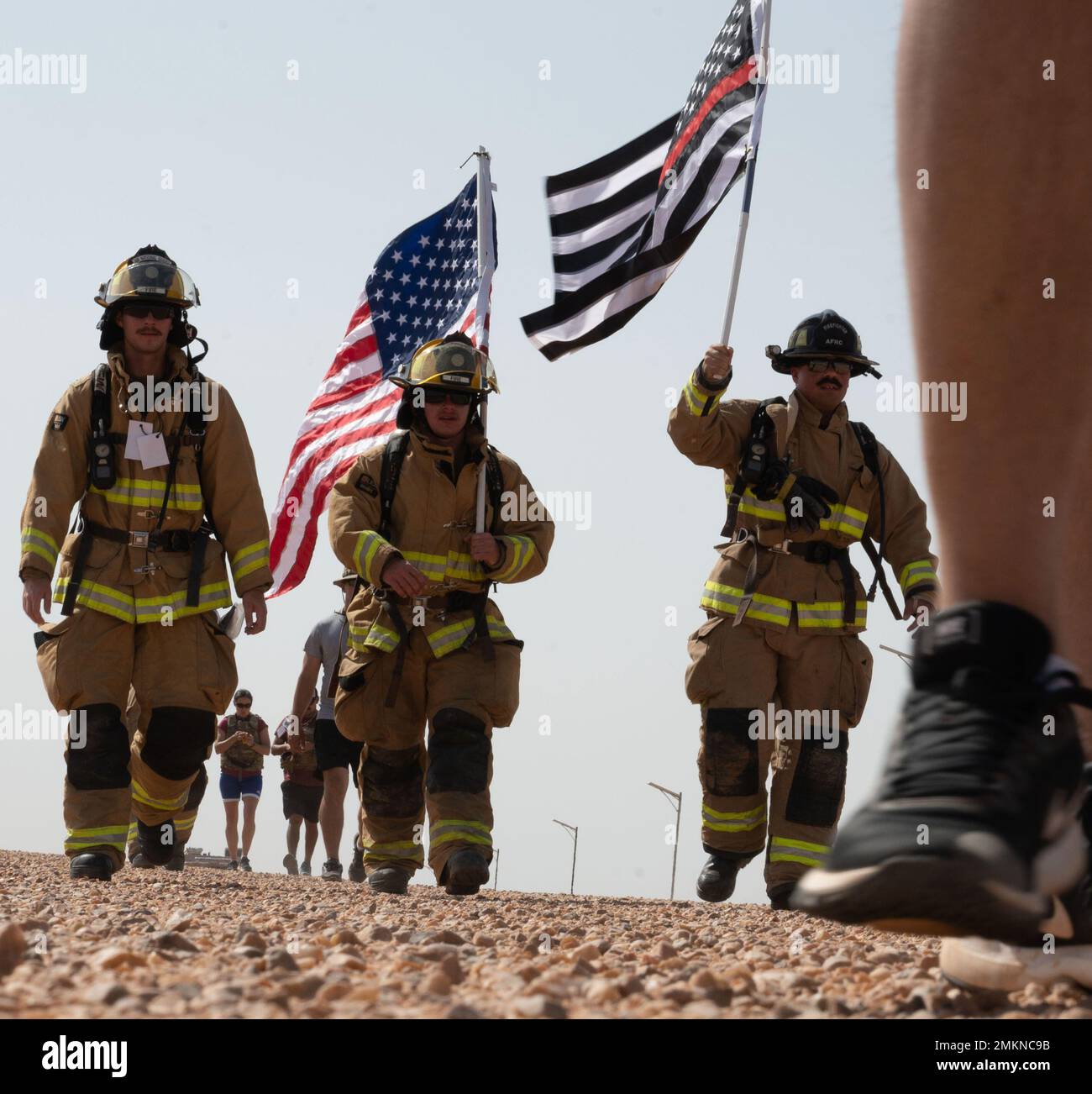 NIGERIEN AIR BASE 201, Niger - Mitglieder des 724. Expeditionary Air Base Squadron Fire and Emergency Services Flight tragen sowohl die US-Flagge als auch die rote und blaue Flagge der Thing Line während eines Ruck marsches zur Erinnerung an die Angriffe auf den Luftwaffenstützpunkt Niger am 9/11, 201, Niger, 11. September, 2022. Die rote Linie auf der Flagge symbolisiert den Mut der Feuerwehrleute, während die blaue Linie den Mut der Strafverfolgungsbehörden symbolisiert. Stockfoto