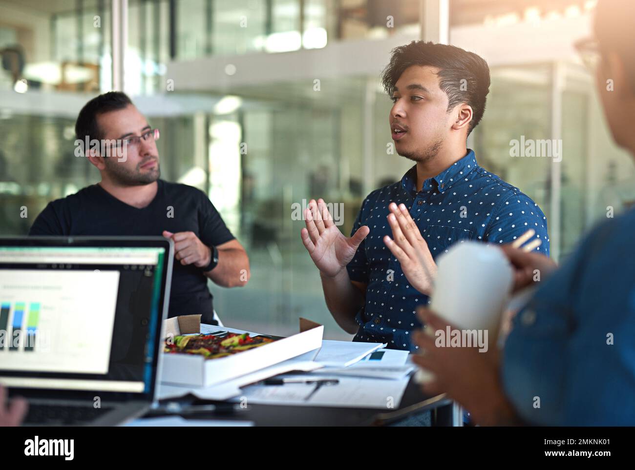 Hören Sie mir zu... eine Gruppe von Kollegen, die während eines Meetings im Sitzungssaal essen. Stockfoto