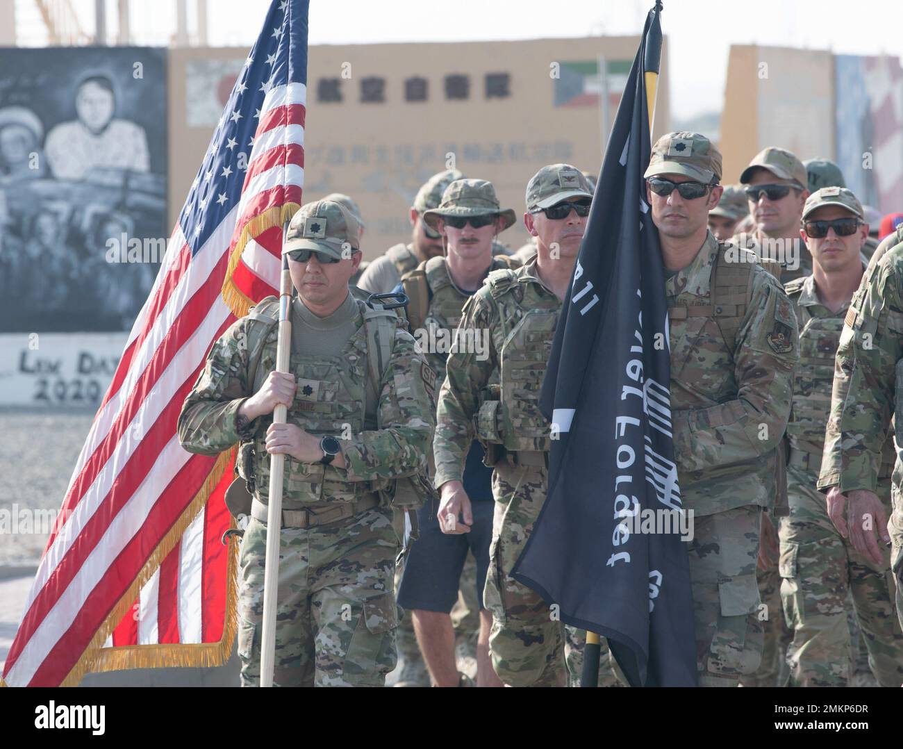Die US-Luftstreitkräfte und die Koalitionspartner der Ali Al Salem Air Base, Kuwait, begeben sich am 11. September 2022 in die erste Runde eines 24-stündigen Ruck-marsches, der von den Kommandeuren jeder Eheleute-Staffel auf der Basis geführt wird. Der Ruck begann um 15:46 Uhr Arabische Standardzeit - die genaue Zeit, zu der das erste Flugzeug den World Trade Center North Tower traf, als es von Eastern Daylight Time an diesem Tag umgebaut wurde, und fuhr 24 Stunden weiter. Die Fahnen wurden über den gesamten Ruck getragen. 386. AEW, 11. September, Patriot Day, 11. September, The Rock, Ruck, Stockfoto