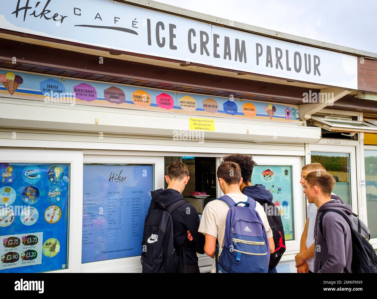 DORSET, Großbritannien - 07. Juli 2022. Teenager-Jungs kaufen Eis in einem Laden oder Eisdiele. Hengistbury Head, Dorset, Großbritannien Stockfoto