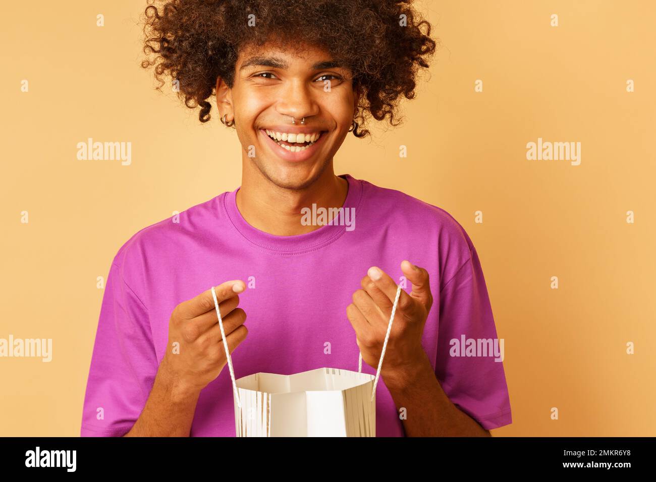 Fröhlicher Mann mit Einkaufstaschen in der Hand Stockfoto