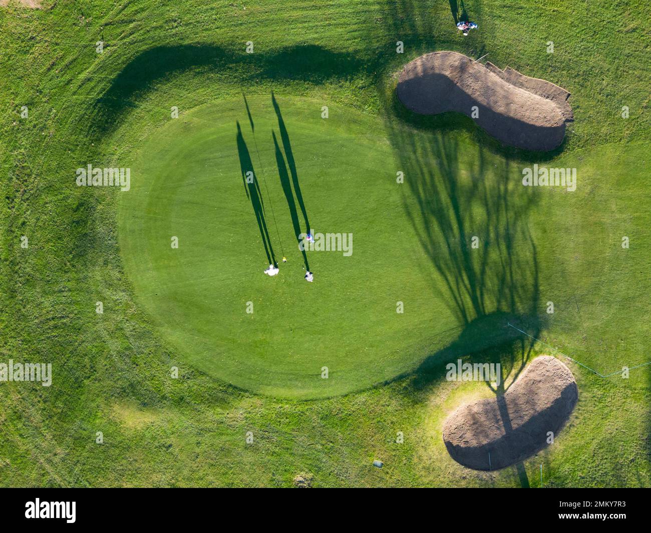 Edinburgh, Schottland, Großbritannien. 26. Januar 2023 Drohnenbild von Schatten der Wintersonne, die von Golfern auf einem Grün auf dem Kingsknowe Golf Course in Edinburgh geworfen werden. Stockfoto