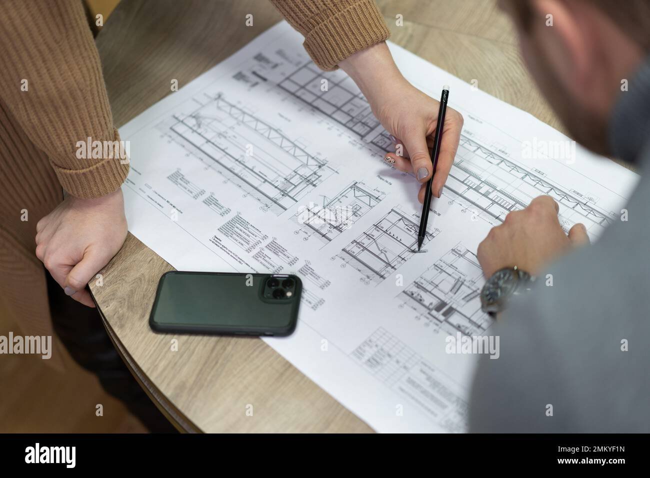 Bauprojektzeichnungen werden von Mitarbeitern des Bauunternehmens besprochen Stockfoto