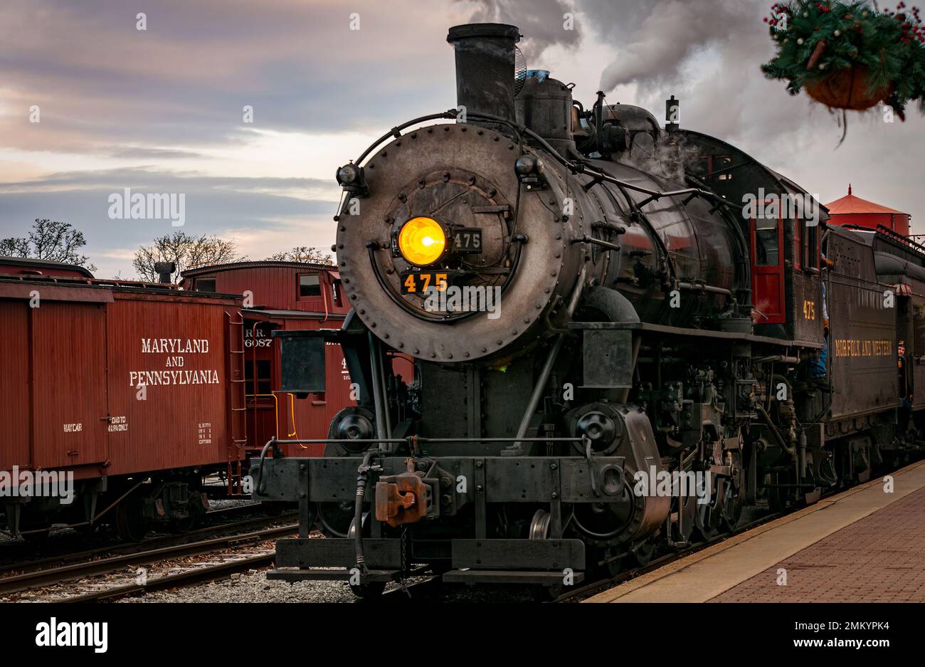 Strasburg, Pennsylvania, 27. Dezember 2022 - A View of a Classic Steam Passenger Train Arrival in a Train Station Blowing Smoke and Steam, an einem Wintertag Stockfoto