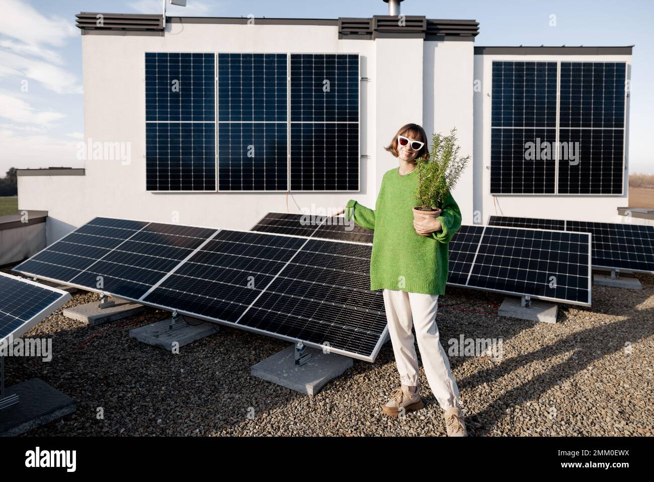 Glücklicher Hausbesitzer mit einer Solaranlage Stockfoto