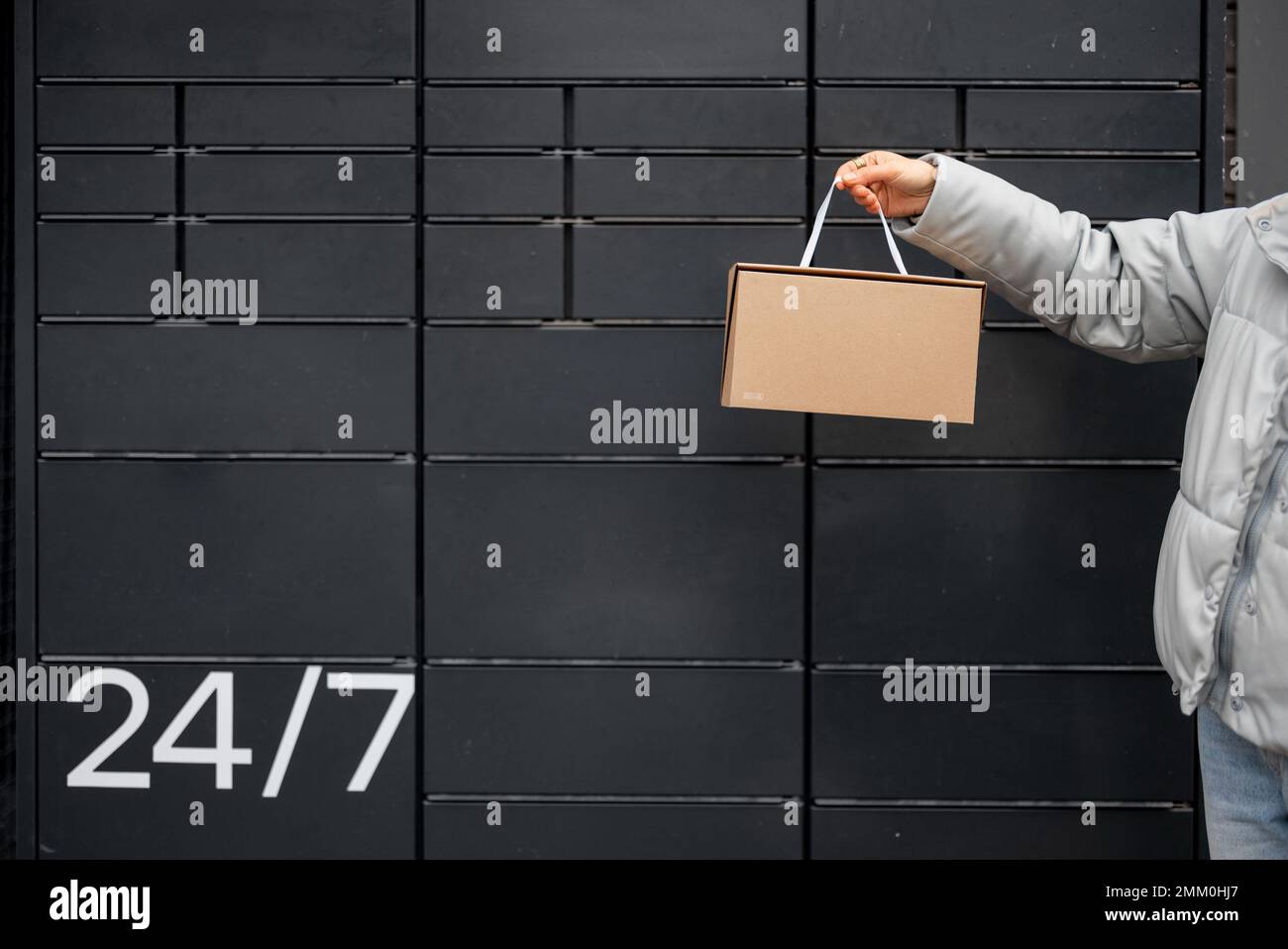 Ein Paket auf dem Hintergrund einer automatischen Postmaschine halten Stockfoto