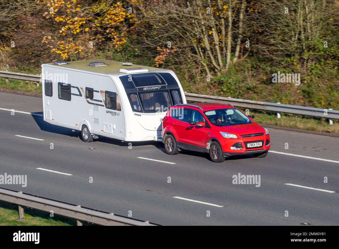 2014 Red FORD KUGA TITAN TDCI 1997cc Diesel Schlepper SWIFT SPRITE Caravan; Fahrt auf der Autobahn M61 UK Stockfoto