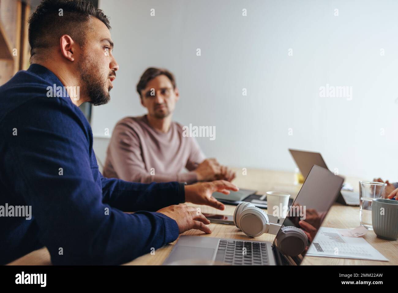 Fachleute, die ein Meeting in einer Marketingagentur haben. Kreative Geschäftsleute diskutieren ein Projekt in einem Sitzungssaal. Geschäftsteam, das in einer Werbung arbeitet Stockfoto