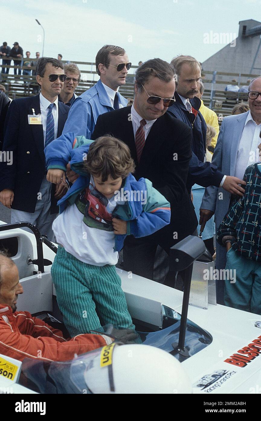 Carl XVI Gustaf, König von Schweden. Geboren am 30. april 1946. Der König Carl XVI Gustaf hilft seinem Sohn Prinz Carl Philip in einem Rennwagen 1986 Stockfoto