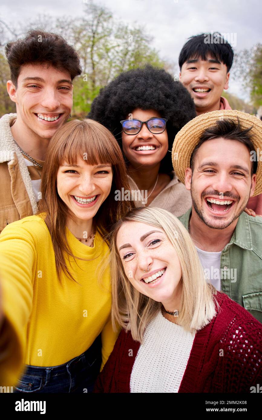 Vertikales Foto einer großen Gruppe fröhlicher junger Freunde, die im Freien ein Selfie-Porträt aufnehmen. Stockfoto