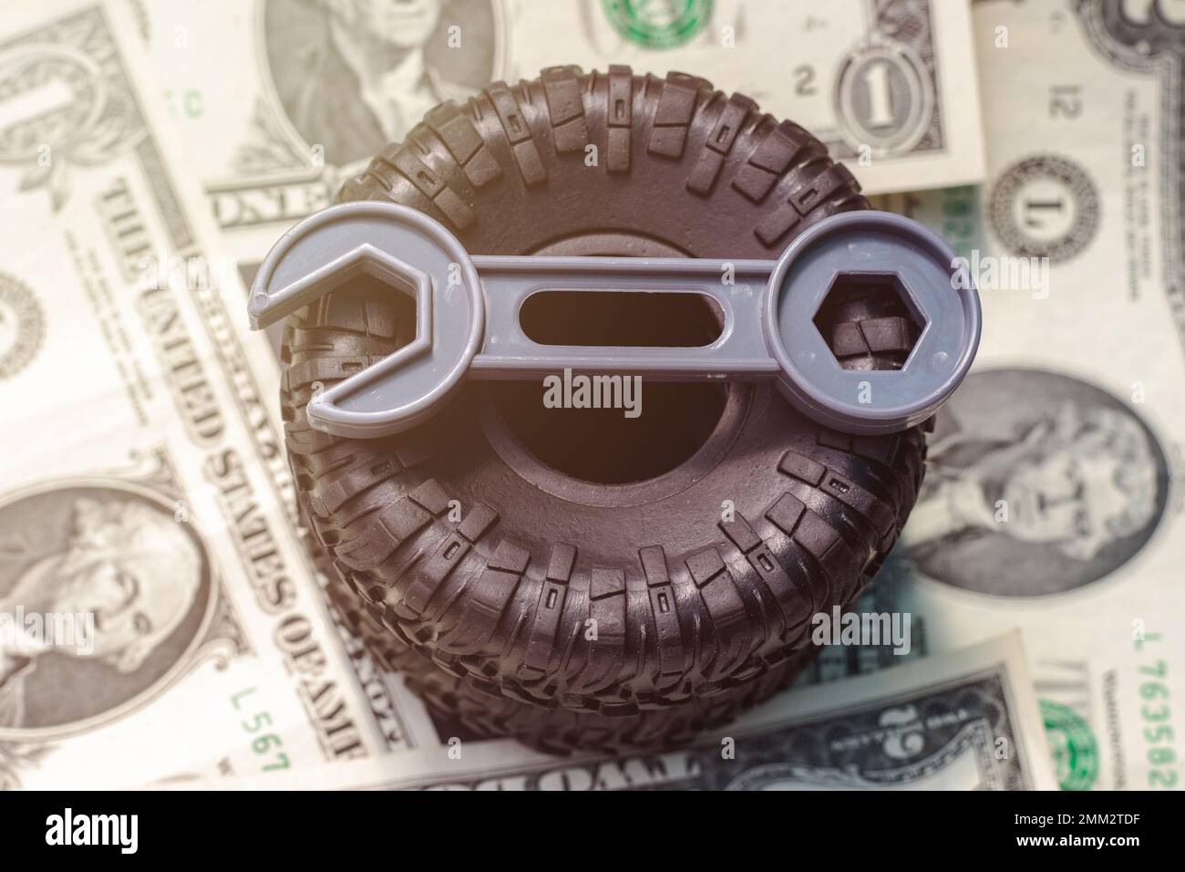 Reifenwechsel Konzept. Schwarze Reifen Kunststoffschlüssel Dollarscheine Stockfoto