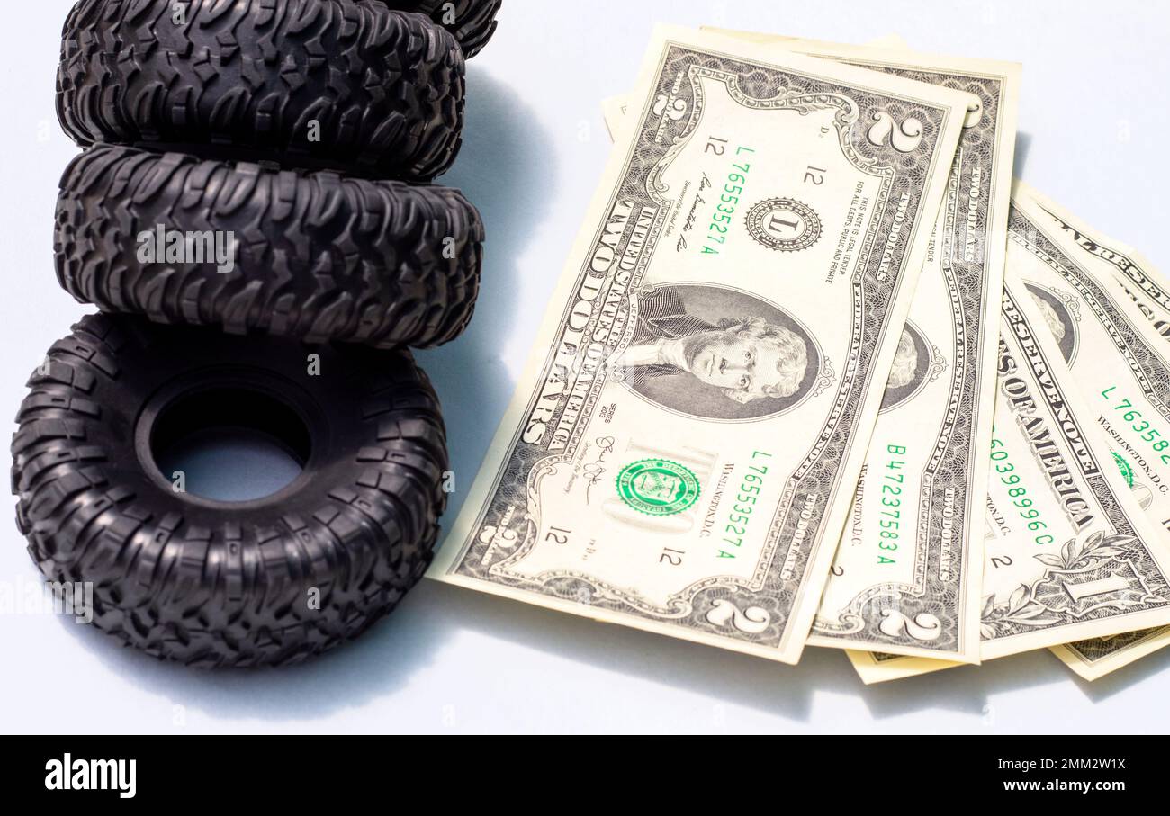 Reifenwechsel Konzept. Schwarze Reifen Kunststoffschlüssel Dollarscheine Stockfoto