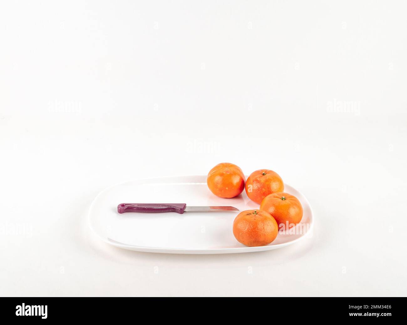 Schüssel mit frischem, reifem Obst auf weißem Hintergrund isoliert. Reife Mandarine mit voller Schärfentiefe. Frische Mandarinen-Mandarinen für rohe Diät. Stockfoto